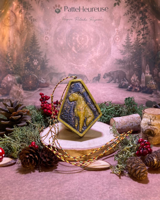 Orgonite qui tien debout sur une rondelle de bois entourer de mousse verte et des cocotte de pin 