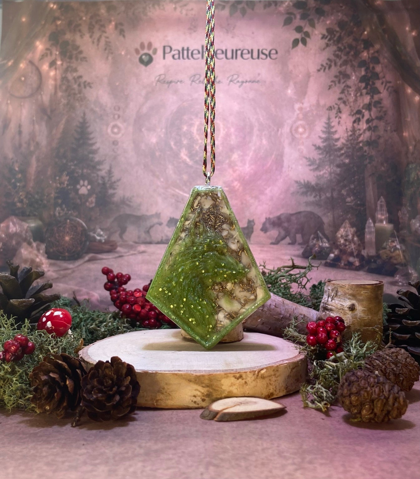  Orgonite blanc avec metaux et un loup vert a paillette suspendu par dessu une rondelle de bois entourer de mousse vert et de cocotte de pin