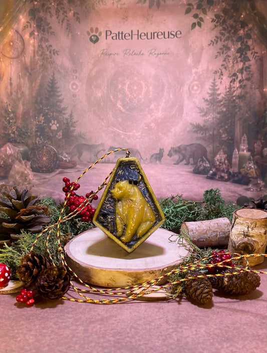 Pendentif ours orgonite qui tien sur un rondelle de bois entourer de mousse verte et de cocotte de pin 